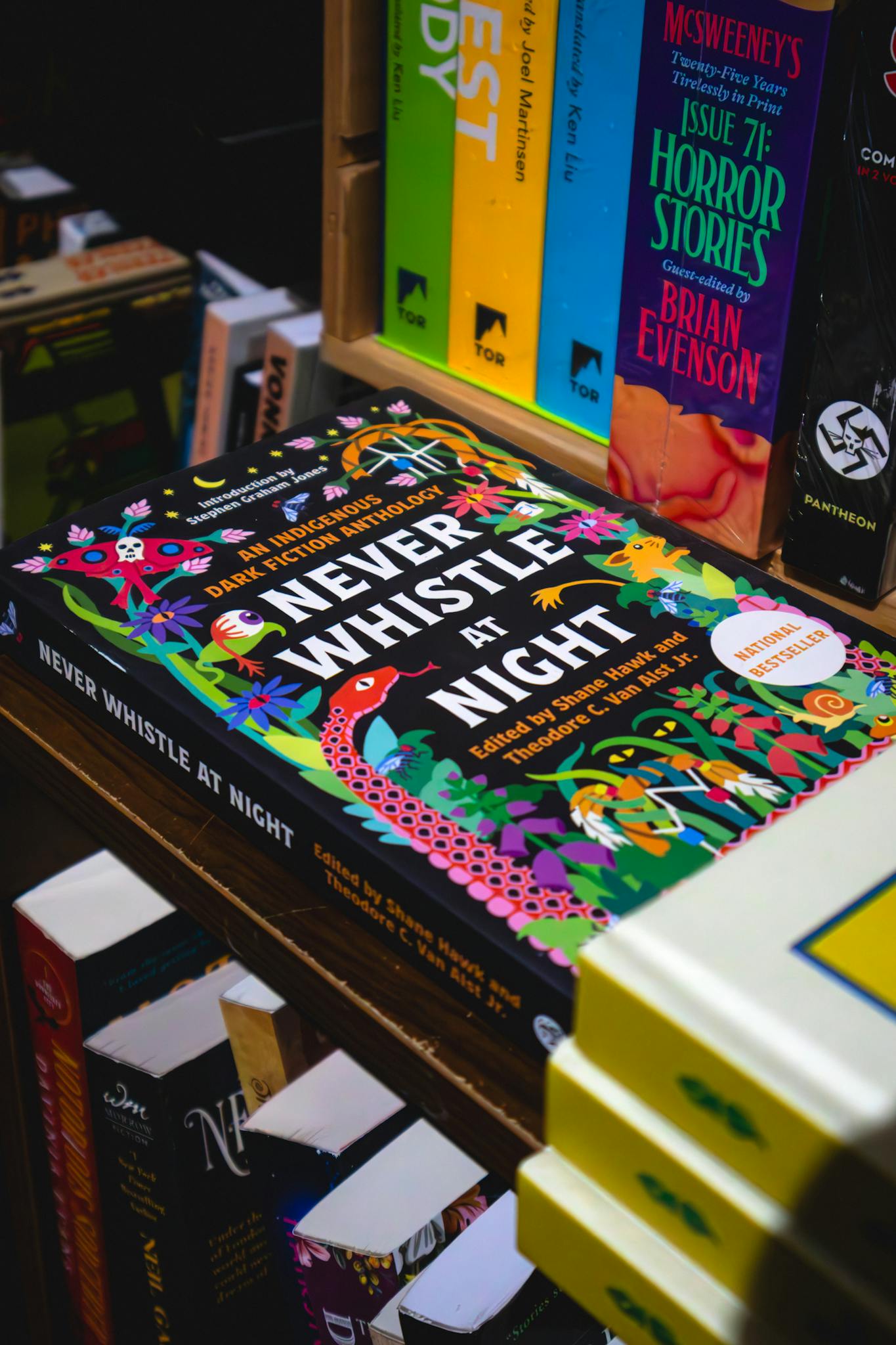 Vibrant book collection showcasing 'Never Whistle at Night' in a Toronto bookstore.